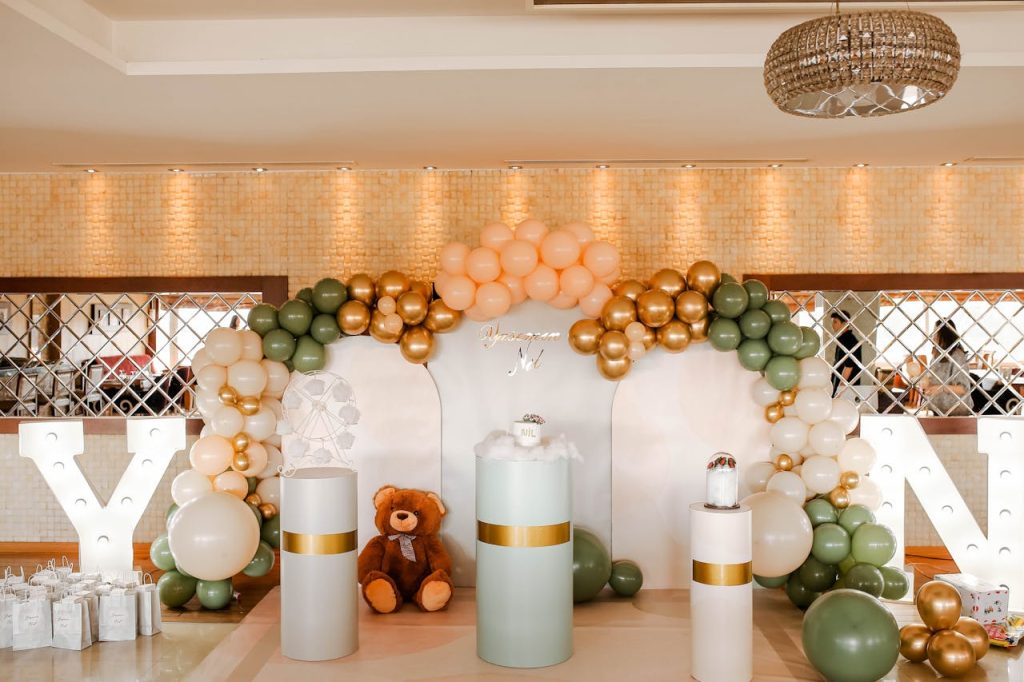 Stylish birthday decor featuring balloons and teddy bear in an elegant indoor setting.